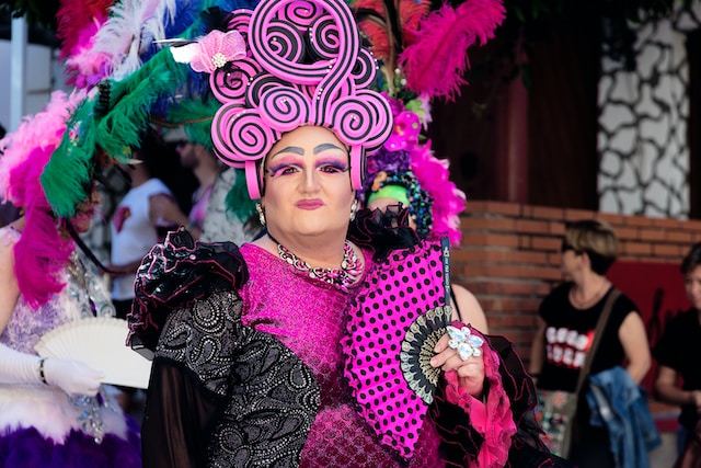 TeA Drag Queen in a black and purple dress wearing a purple and black headdressxt.