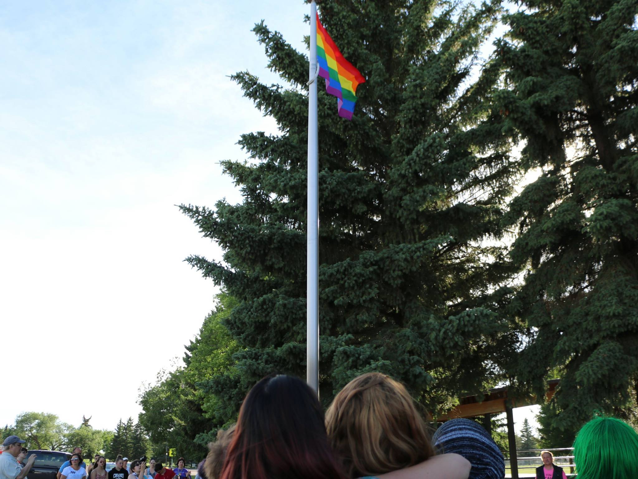 Two people watching the Taber Pride flag being raised for the first time in Taber - June 12, 2017.