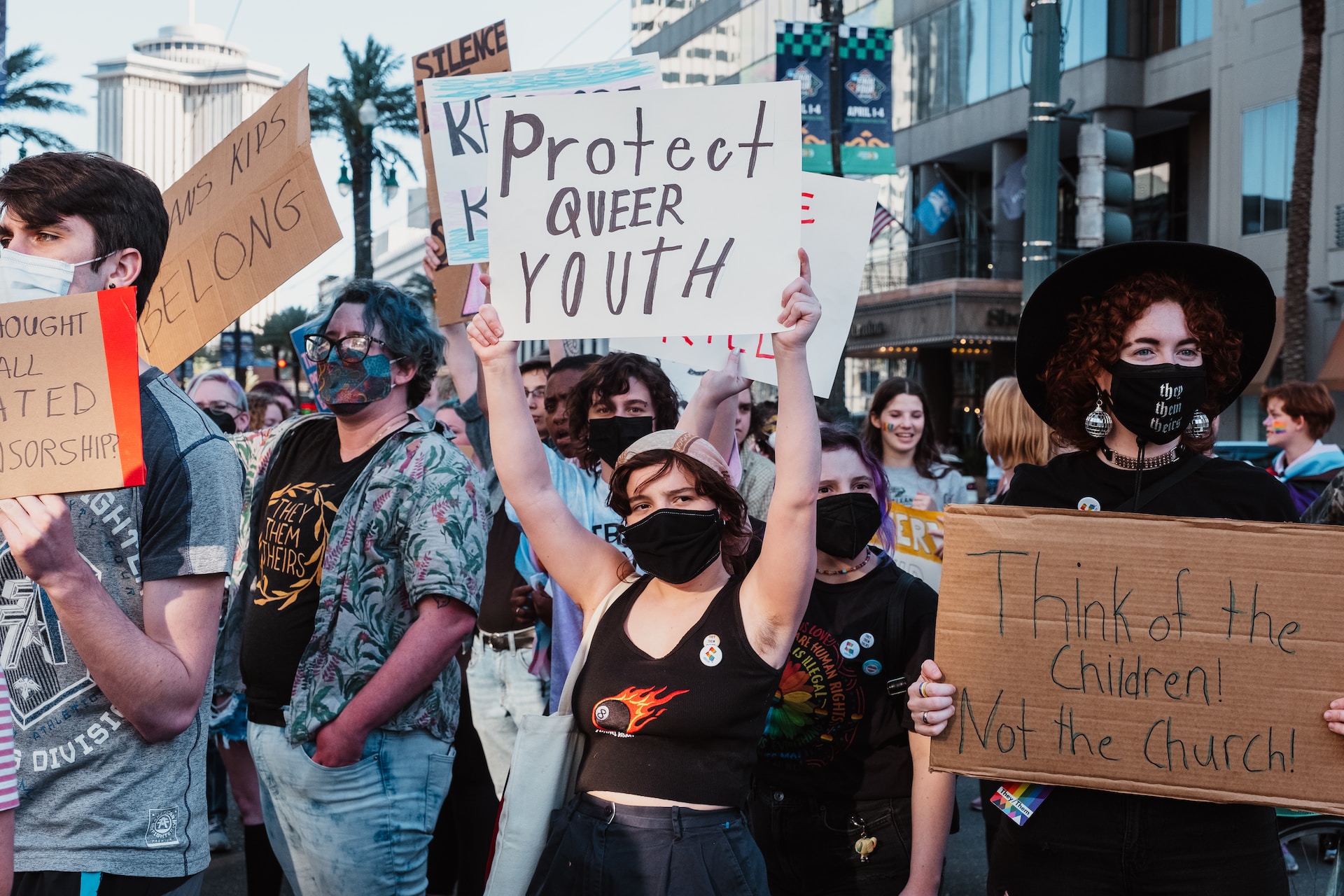 Protestors holding signs: Protect queer kids and Think of the children! Not the Church!